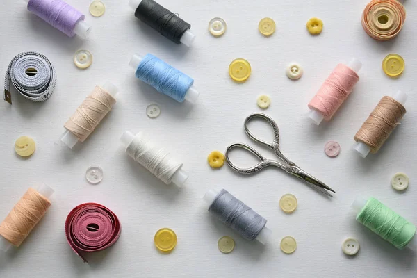 Composition with threads and sewing accessories on a white background, flat lay — Stock Photo, Image