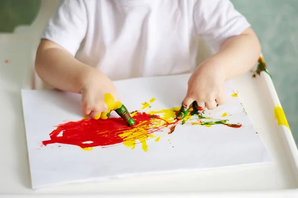 Las palmas de los niños, manchadas de pintura, divierten al niño —  Fotos de Stock