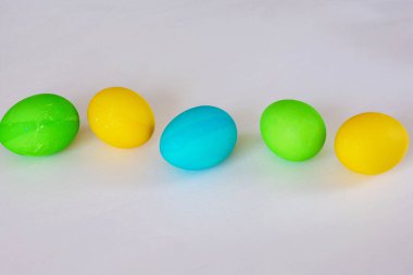 Paskalya yumurtaları beyaz arka planda izole renkli. Minimal Paskalya konsepti. Metin için kopya alanı ile mutlu paskalya kartı. Üst görünüm, düz.