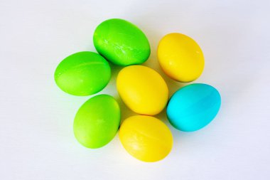 Paskalya yumurtaları beyaz arka planda izole renkli. Minimal Paskalya konsepti. Metin için kopya alanı ile mutlu paskalya kartı. Üst görünüm, düz.