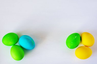 Paskalya yumurtaları beyaz arka planda izole renkli. Minimal Paskalya konsepti. Metin için kopya alanı ile mutlu paskalya kartı. Üst görünüm, düz.