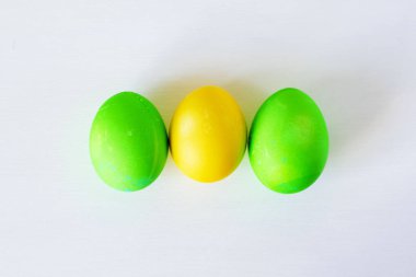 Paskalya yumurtaları beyaz arka planda izole renkli. Minimal Paskalya konsepti. Metin için kopya alanı ile mutlu paskalya kartı. Üst görünüm, düz.
