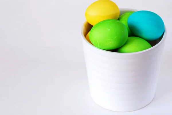 Velikonoční vajíčka s různobarevnými izolovanými na bílém pozadí. Minimální velikonoční koncept. Šťastná velikonoční karta s prostorem pro kopírování textu. Pohled shora, plochý. — Stock fotografie