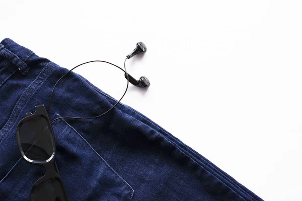 Headphones and glasses in the jeans pocket on a white background Stock Picture