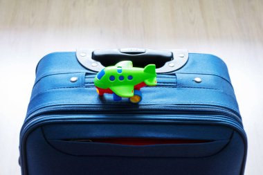 Kahverengi arka plan üzerinde mavi bir bavul. Mavi bavul