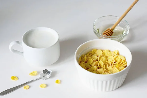 Café da manhã saudável com flocos de milho e leite sobre fundo branco — Fotografia de Stock
