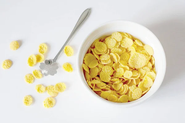 Gesundes Frühstück mit Cornflakes und Milch vor weißem Hintergrund — Stockfoto