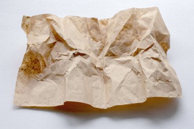 Hafif bir arka plan üzerinde buruşturulmuş bir kağıt parçası.