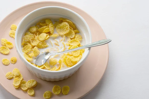 Gesundes Frühstück mit Cornflakes und Milch vor weißem Hintergrund — Stockfoto