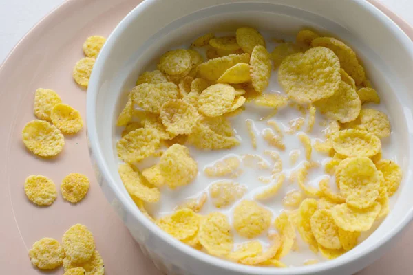 Gesundes Frühstück mit Cornflakes und Milch vor weißem Hintergrund — Stockfoto