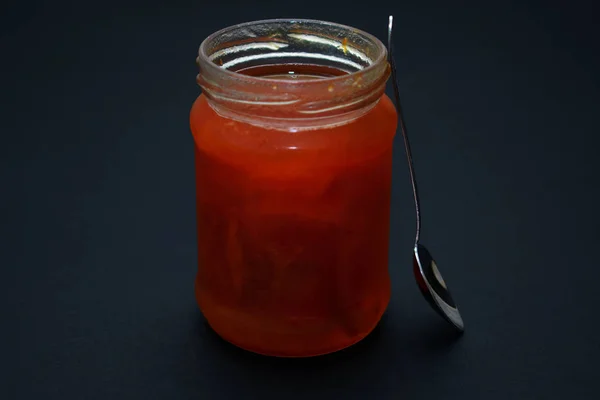 Glass jar of jam on a dark background — Stock Photo, Image