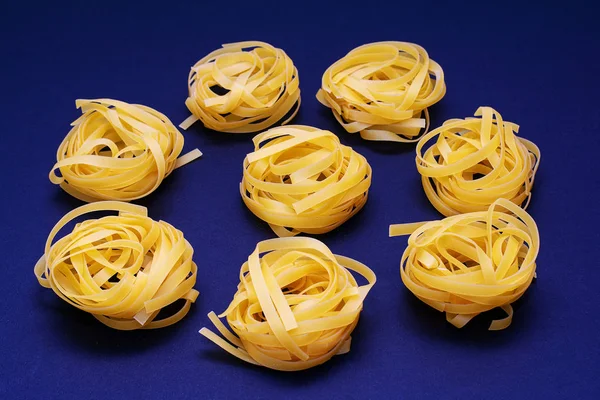 Dry pasta yellow on a dark background. Italian food — Stock Photo, Image