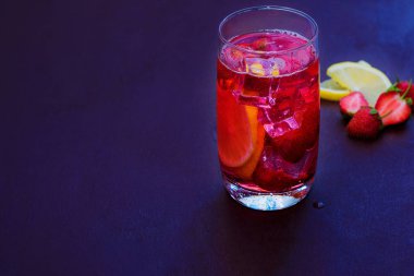 Koyu bir arka plan üzerinde çilek buz ile içilir. Taze çilek kokteyli. Çilek ve buz küpleri ile taze yaz kokteyli. Koyu arka planda çilekli soda içeceği.