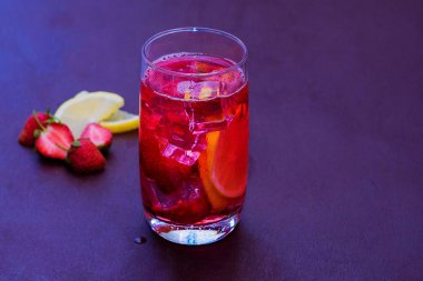 Koyu bir arka plan üzerinde çilek buz ile içilir. Taze çilek kokteyli. Çilek ve buz küpleri ile taze yaz kokteyli. Koyu arka planda çilekli soda içeceği.
