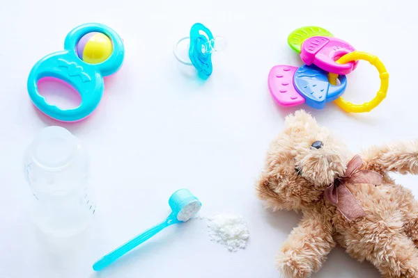 Baby milk powder, baby bottle and children\'s toys on a light background flat lay
