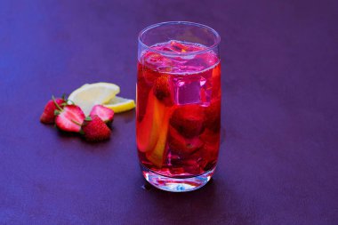 Koyu bir arka plan üzerinde çilek buz ile içilir. Taze çilek kokteyli. Çilek ve buz küpleri ile taze yaz kokteyli. Koyu arka planda çilekli soda içeceği.