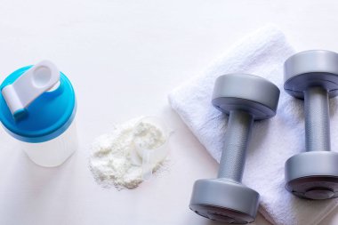 Protein shake, halter ve havlu beyaz arka plan üzerinde