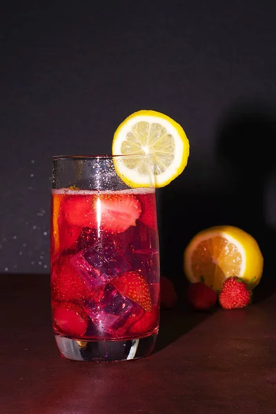 Πίνετε με πάγο από φράουλες σε σκοτεινό φόντο. Φρέσκο κοκτέιλ φράουλας. Φρέσκο καλοκαιρινό κοκτέιλ με φράουλα και παγάκια. Ποτήρι αναψυκτικό φράουλα σε σκούρο φόντο. — Φωτογραφία Αρχείου
