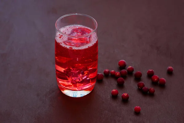 Beba com cranberries com gelo, cranberries em um fundo escuro. Cocktail de cranberry fresco. Cocktail fresco de verão com cranberries e cubos de gelo . — Fotografia de Stock