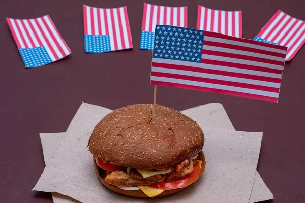 Composición con bandera americana y hamburguesa sobre fondo oscuro. Bandera americana, Bandera USA — Foto de Stock