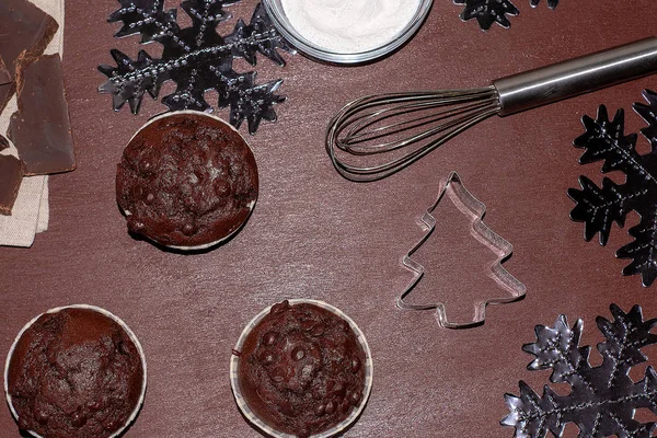 Pasteles e ingredientes sobre un fondo oscuro. Hornear un cupcake para Navidad — Foto de Stock