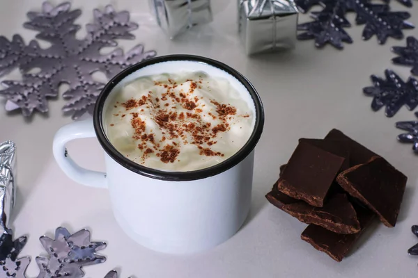Una taza de chocolate caliente en una mesa de madera blanca. Bebida tradicional de Navidad, copos de nieve y regalos . — Foto de Stock