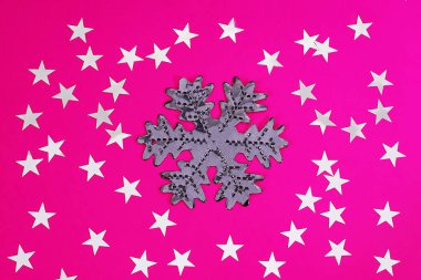 Kar tanesi ve konfeti pembe bir arka plan üzerinde bir yıldız şeklinde. Şenlikli arka plan. Tatil konsepti. Noel ve Yeni Yıl konsepti. Üst görünüm, düz yatıyordu
