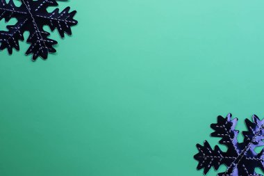 Yeşil arka planda kar taneleri. Şenlikli arka plan. Tatil konsepti. Noel ve Yeni Yıl konsepti. Üst görünüm, düz yatıyordu