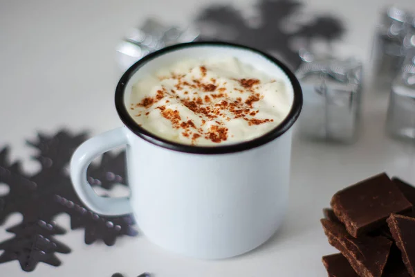 Una taza de chocolate caliente en una mesa de madera blanca. Bebida tradicional de Navidad, copos de nieve y regalos . — Foto de Stock