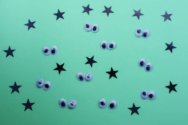 Yeşil arka planda dekoratif gözler. Halloween kavram Trick veya tedavi. Cadılar Bayramı için yaratıcı bir konsept. Düz döşeme, üst görünüm, kopyalama alanı