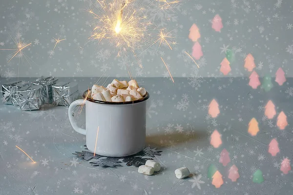 Witte metalen mok cacao of warme chocolademelk met marshmallows op een tafel met nieuwjaarsdecor en sprankelende bokeh lichtjes op de achtergrond. Kersthuisconcept — Stockfoto