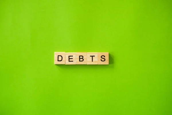 Palabra Debts Shot Flat Yacía Sobre Fondo Verde Aislado —  Fotos de Stock