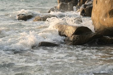 Deniz dalgaları sahilde kayaları vuruyor.