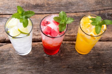 Ahşap arka planda limon, portakal, karpuz soda içecekler bardak