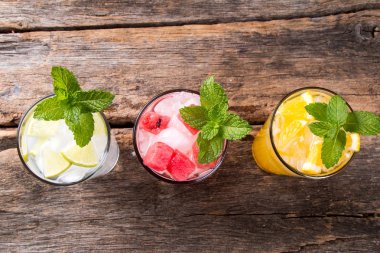 Ahşap arka planda limon, portakal, karpuz soda içecekler bardak
