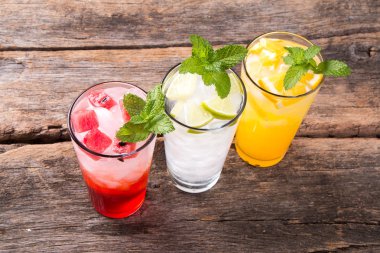 Ahşap arka planda limon, portakal, karpuz soda içecekler bardak