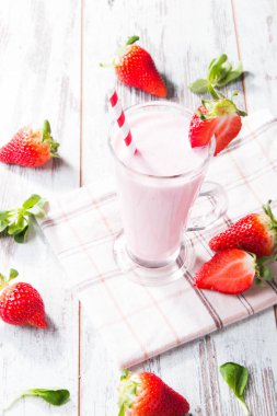 Taze süt, tahta masada çilek, taze meyveli çeşitli protein kokteylleri. Doğal arka plan.