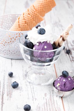 Ahşap masada tatlı koni içinde dondurma kepçe 