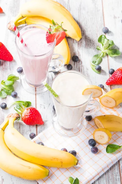新鲜牛奶 香蕉在木桌上 各种蛋白质鸡尾酒与新鲜水果 自然背景 — 图库照片