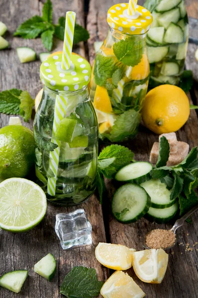 Glasses of lime, lemon soda drinks on wooden background