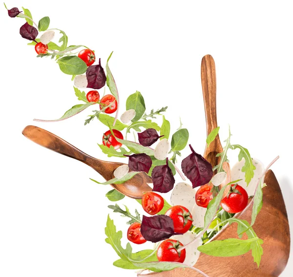 沙拉在沙拉碗里掉下来 在白桌上分离的混合蔬菜 免版税图库照片