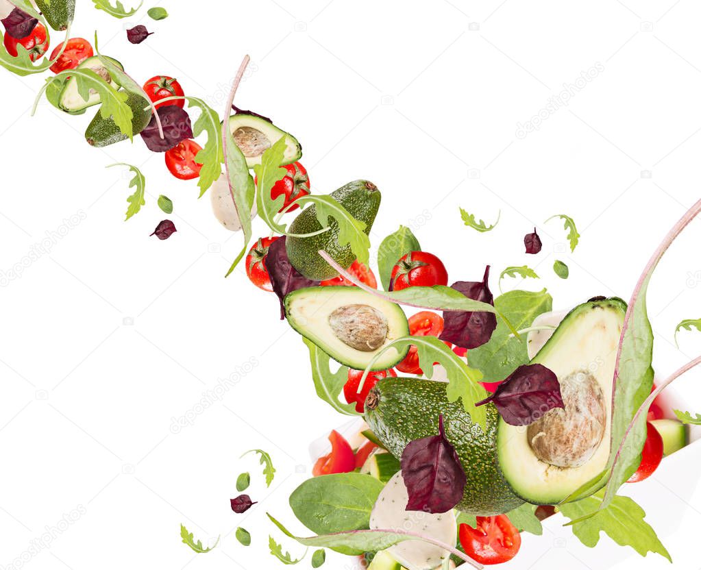 Falling salad in salad bowl. Mix vegetable isolated on white table. 