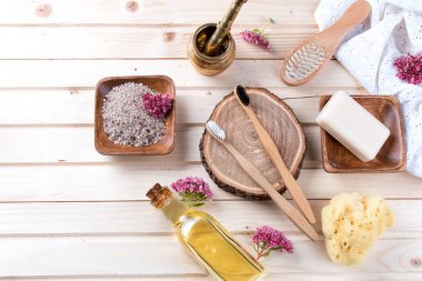 Sıfır atık banyo aksesuarları, doğal fırça, yağ, deniz tuzu, saç, diş fırçası, ahşap arka plan havlu