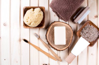 Sıfır atık banyo aksesuarları, doğal fırça, yağ, deniz tuzu, saç, diş fırçası, ahşap arka plan havlu