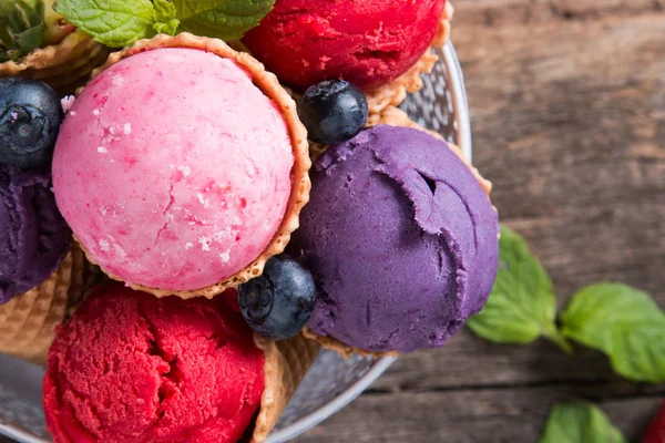 Ice cream scoops in sweet cone. Raspberry, blueberry and strawberry mix scoop. Sundae, summer concept.