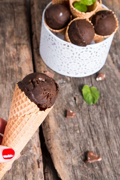 Ice cream scoops in sweet cone on wooden tbale. Chocolate sundae