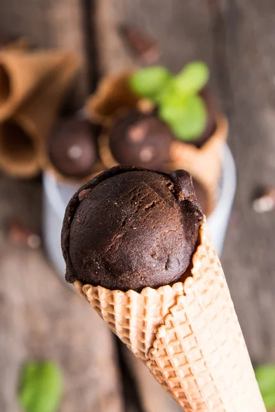 Ice cream scoops in sweet cone on wooden tbale. Chocolate sundae