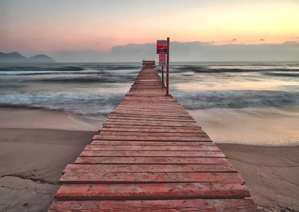 Pier / jetty playa de muro, alcudia, nascer do sol, montanhas, praia isolada, Maiorca, Espanha . — Fotografia de Stock