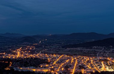 Son Servera kasaba Akdeniz sahiline dağlar üzerinden önde gelen karanlık şehir ışıkları aydınlatılmış, Mallorca, Ispanya.