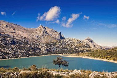Cuber resevoir, göl, Puig Major, Tramuntana, hava istasyonu, ağaçlar, kayalar, güneş ışığı, düşük beyaz bulutlar, Turkuaz su, Mallorca, Ispanya.